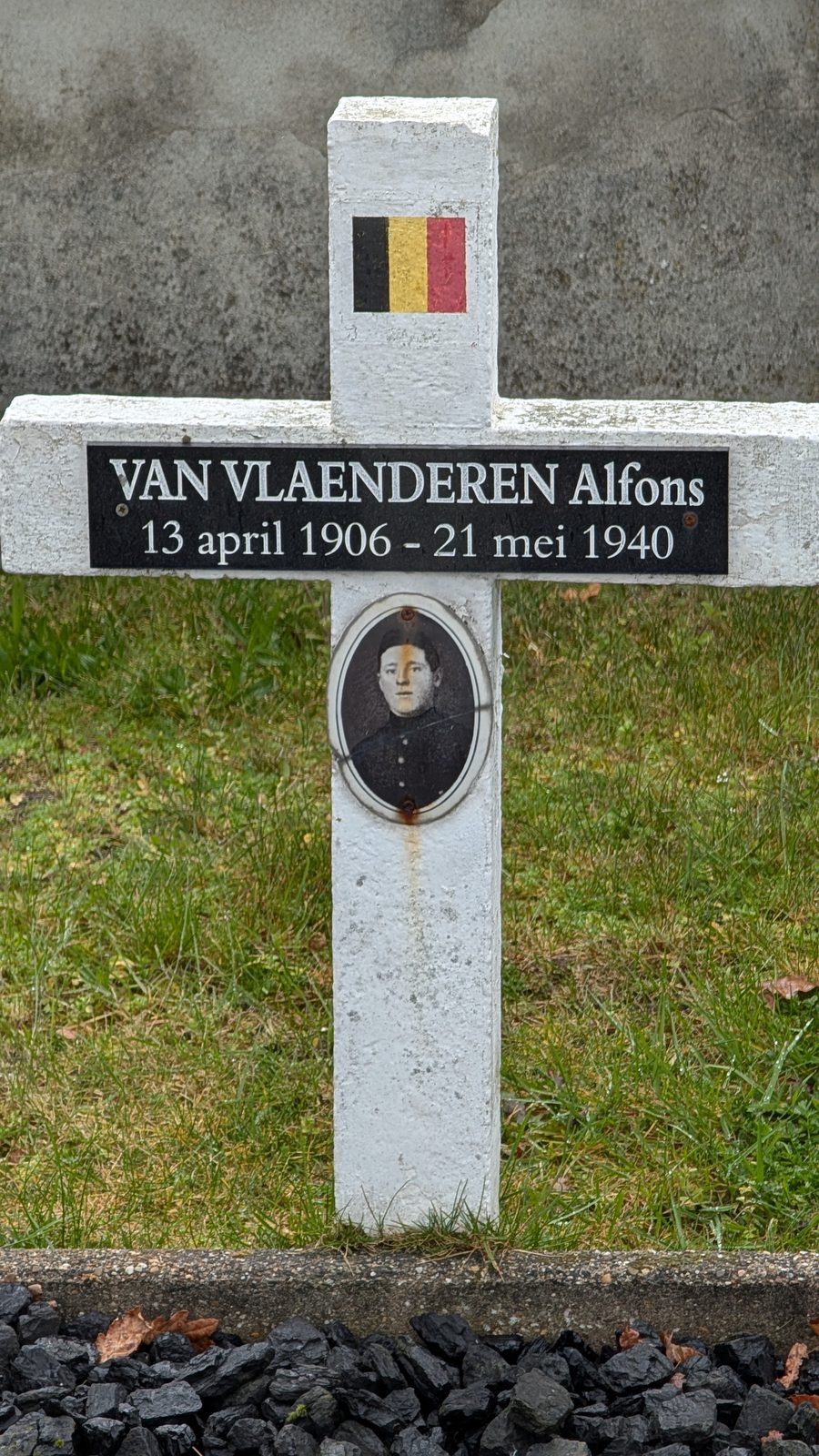 The white field cross of Alfons Van Vlaenderen at Eeklo, with Belgian tricolour and portrait.