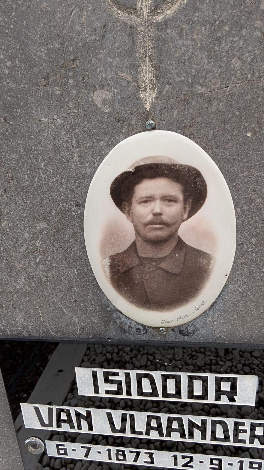 The grave of Isidoor Van Vlaenderen at Boekhoute, with a ceramic portrait above the name plate.